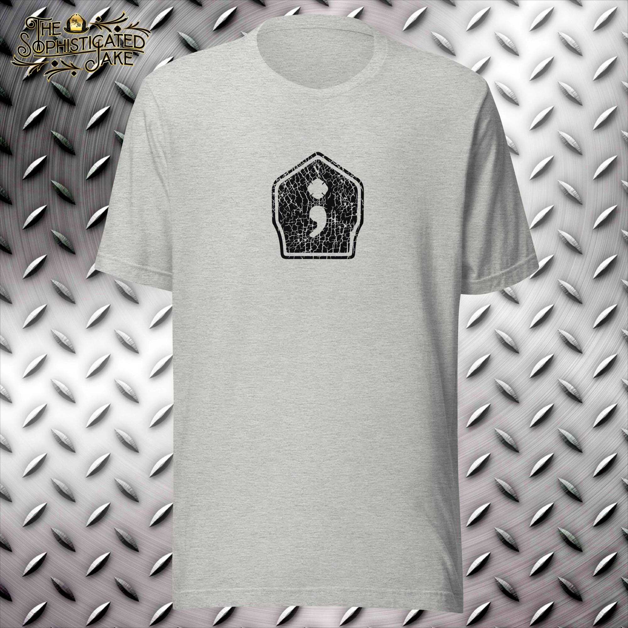 Grey t-shirt with a center design on the chest of a firefighter's helmet shield that is distressed.  The center of the shield has a graphic of a semicolon with the maltese cross incorporated at the top.
