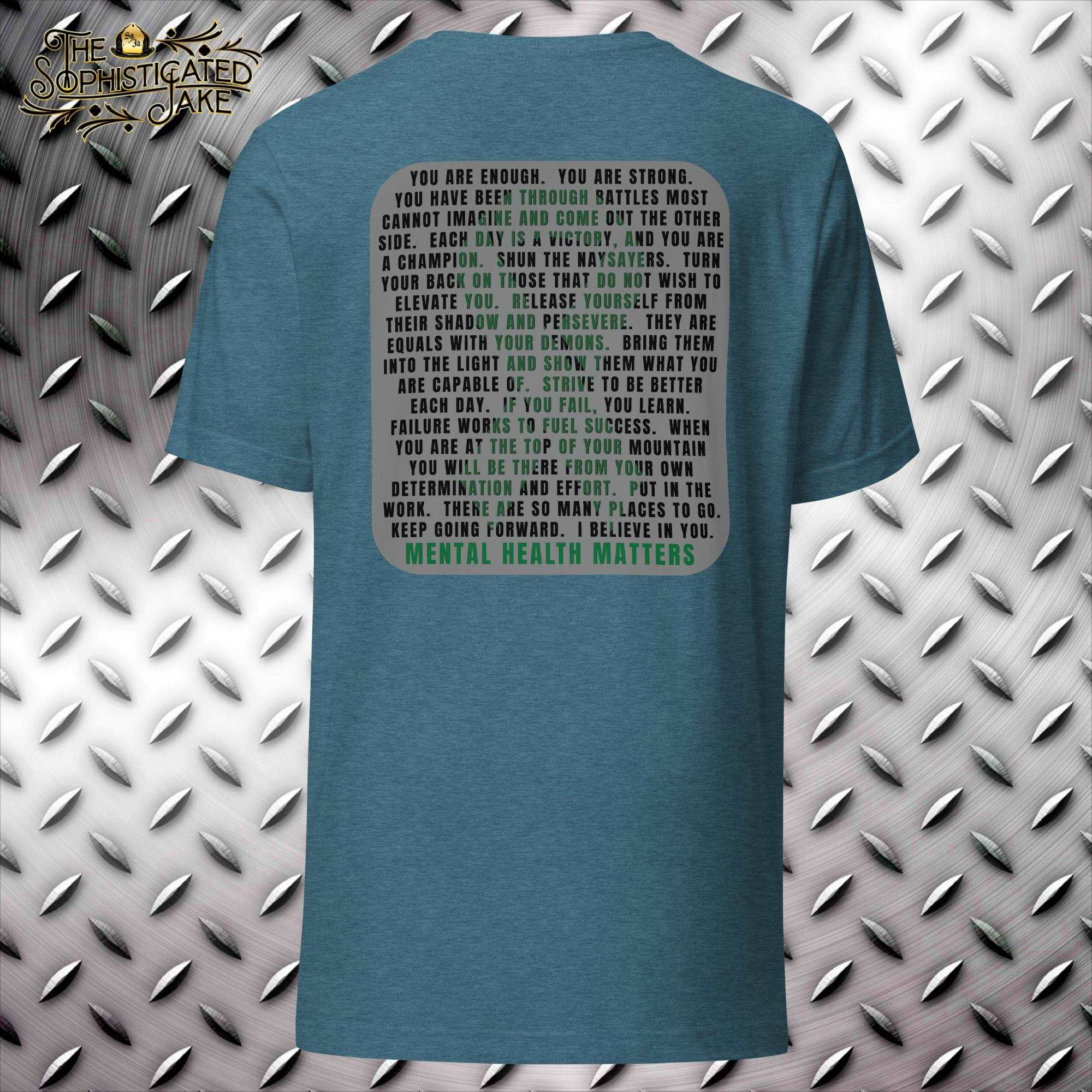 Teal t-shirt with the Sophisticated Jake logo on the front left breast consisting of text with irons incorporated into and fire helmet with the brand's initials SO/JA.  On the back in text is an inspirational quote that has alternating colors to display a green ribbon.  Text reads, "You are enough.  You are strong.  You have been through battles most cannot imagine and come out the other side.  Each day is a victory, and you are a champion.  Shun the naysayers.  Turn your back on those  that do not wish to 