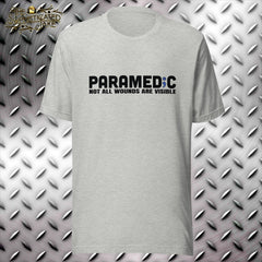 grey t-shirt with graphic in the center of the chest.  Text reads, "Paramedic, not all wounds are visible" with the "I" in paramedic replaced with a semicolon incorporating the star of life.